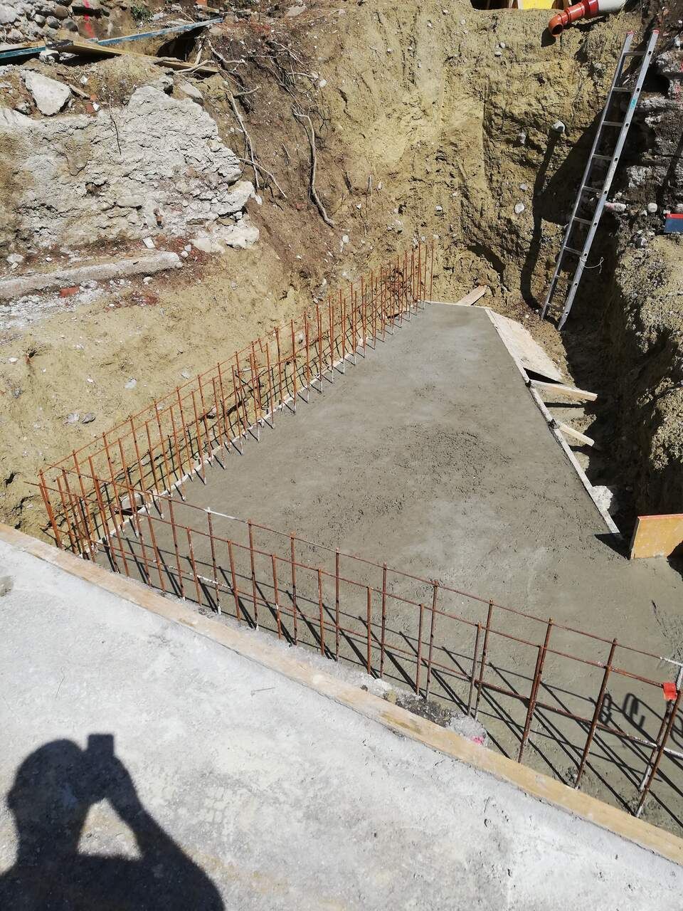 Chantier de construction avec coulage de dalle en béton.