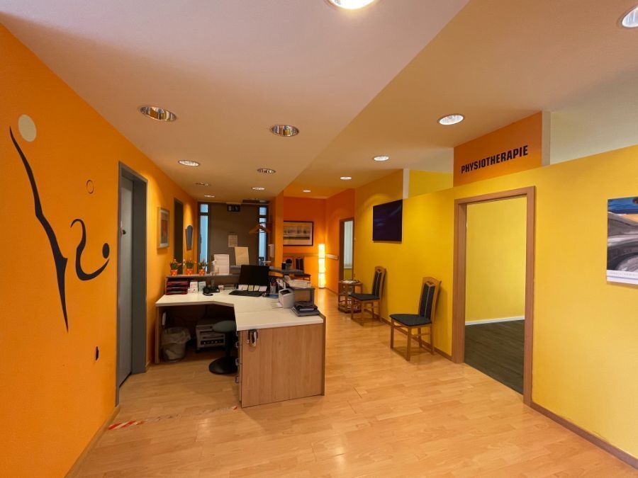 Leuchtend orangefarbene Büroeinrichtung mit Empfangstresen, Stühlen und Türen.