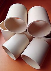 Seis tazas blancas, cilíndricas, apiladas juntas.