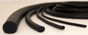 Una vista de cerca de varios cordones de caucho cilíndricos negros de distintos espesores dispuestos en una fila curva.