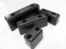 Parachoques de goma rectangulares de color negro con dos agujeros cada uno, sobre fondo blanco.