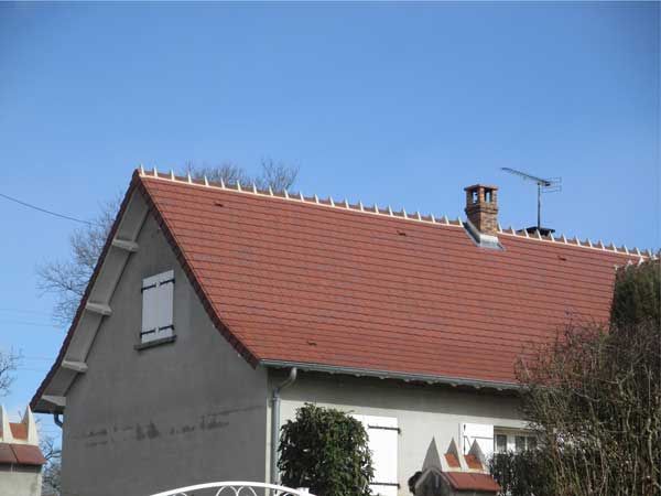 Maison aux murs blancs et au toit de tuiles rouges sous un ciel bleu dégagé