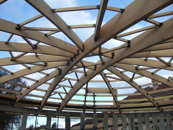 Structure de toiture en treillis de bois en cours de construction sur fond de ciel bleu