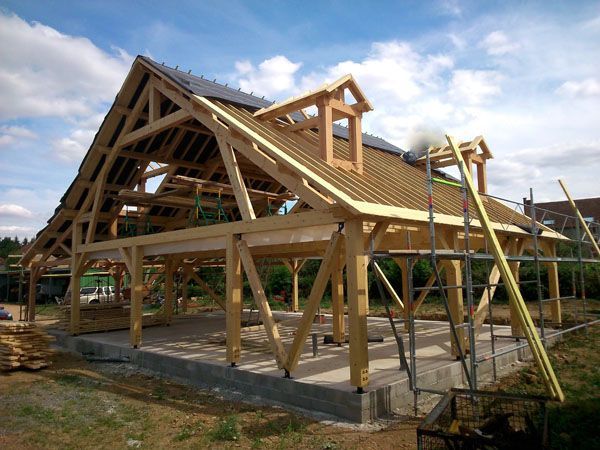 Ossature en bois partiellement construite sur des fondations en béton, sur un chantier