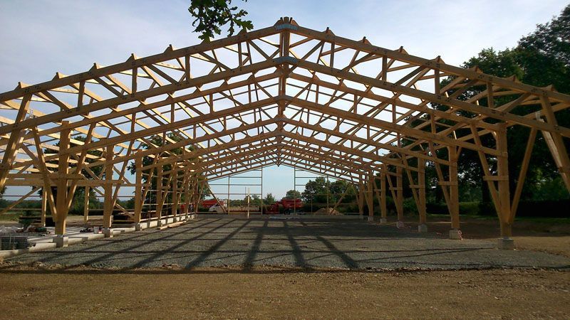 Structure ouverte de pavillon en bois en construction sur un terrain gravillonné