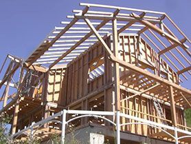 Ossature en bois d’une maison en construction sur fond de ciel bleu dégagé