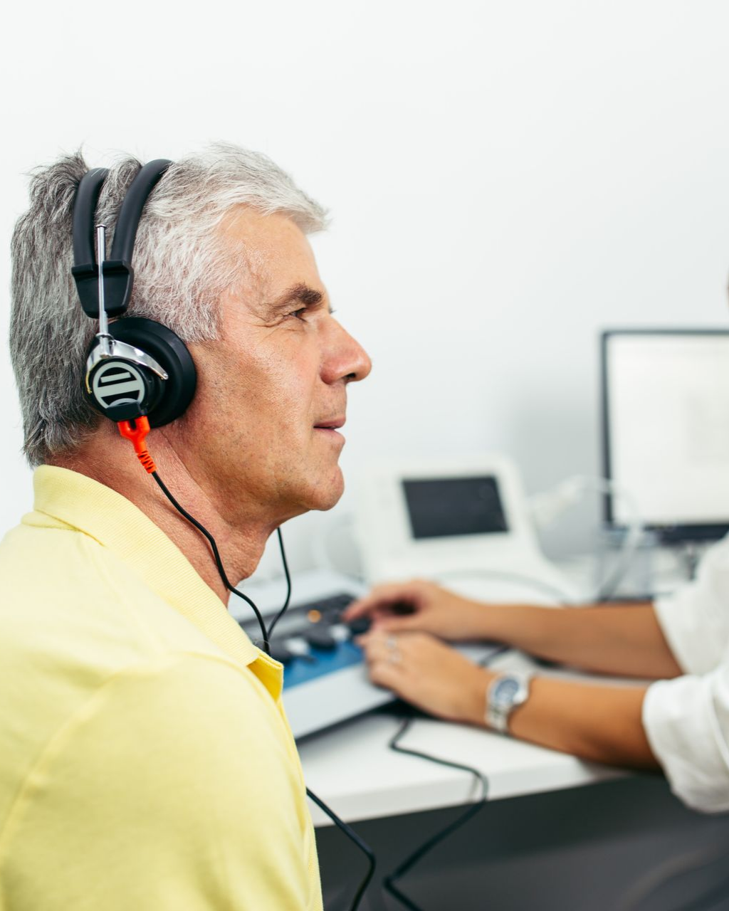 Un homme porte un casque audio lors d'un test auditif en clinique.