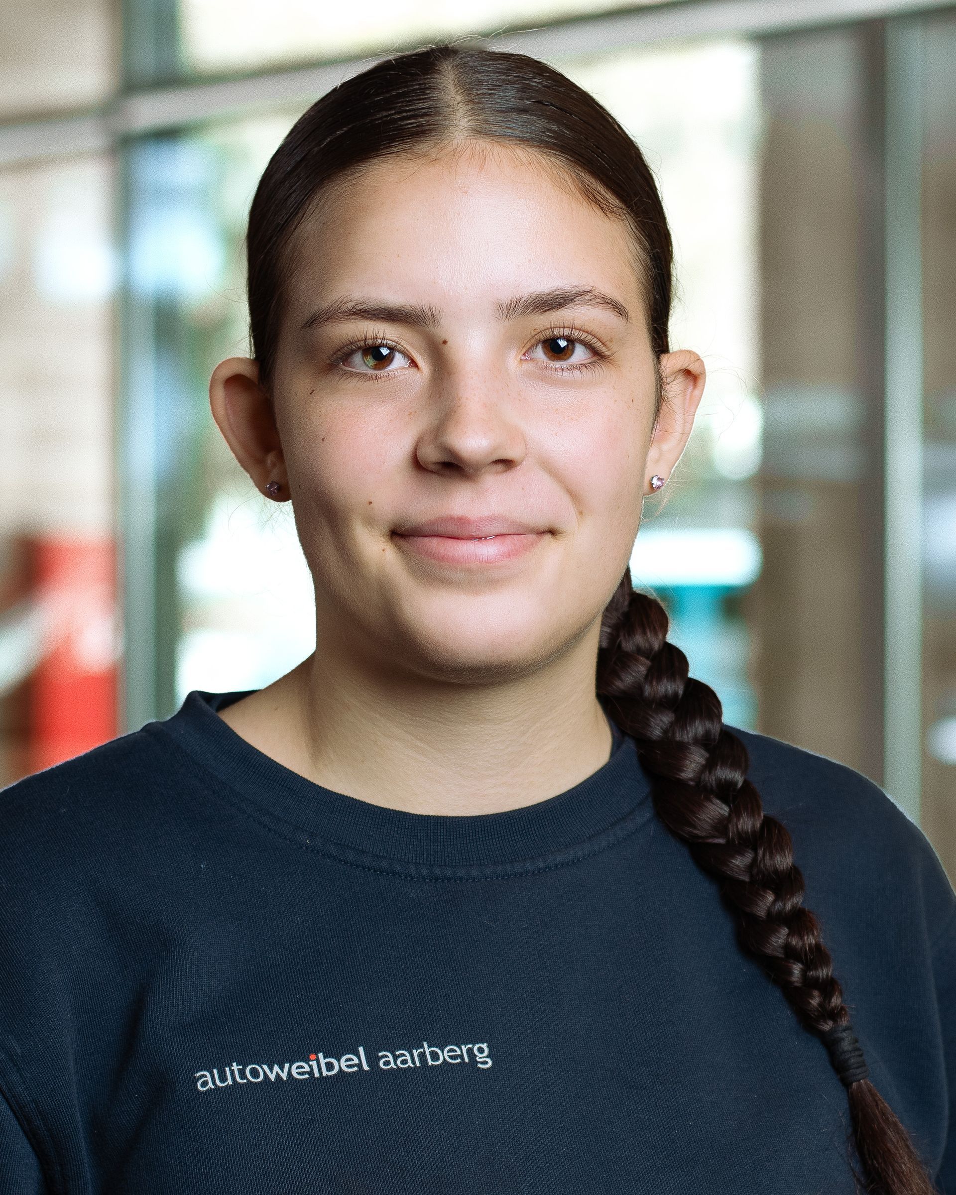 Ein junger Mann mit blondem Haar trägt einen schwarzen Pullover und lächelt in die Kamera.