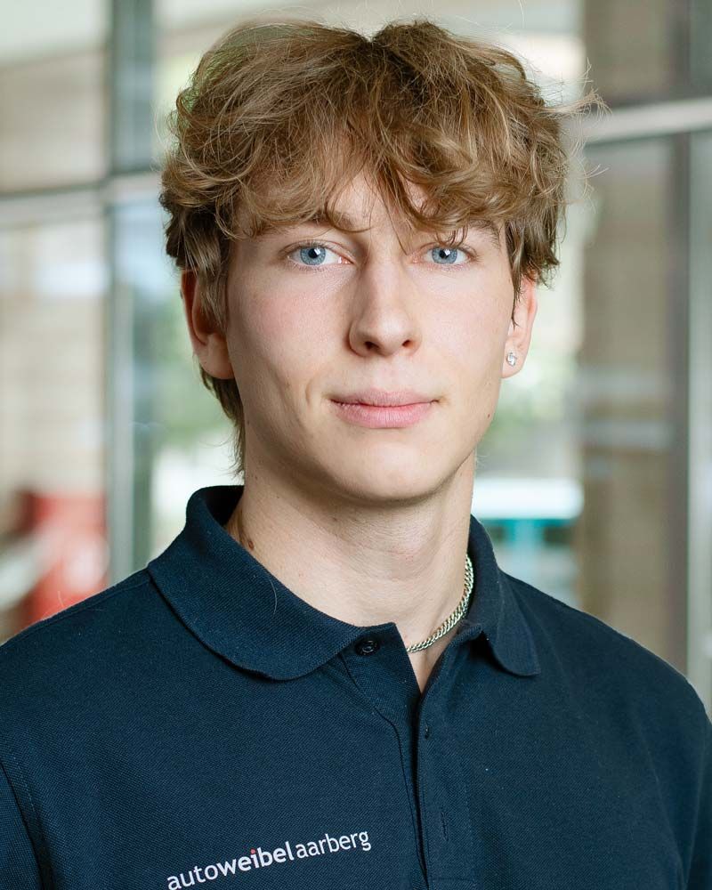 Eine Frau in einem schwarzen Poloshirt lächelt in die Kamera.