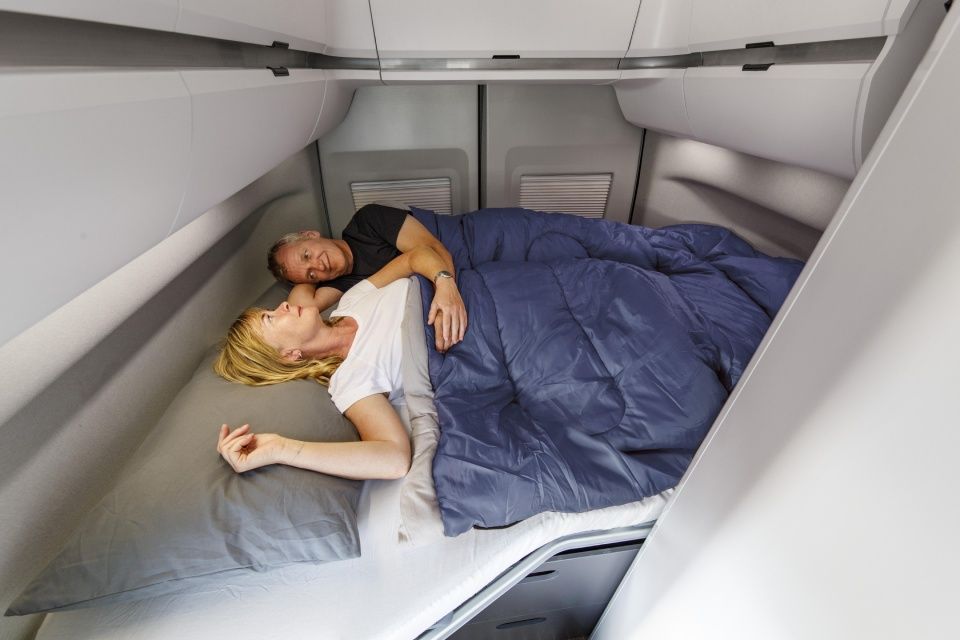 Ein Mann und eine Frau schlafen in einem Bett in einem Camper.