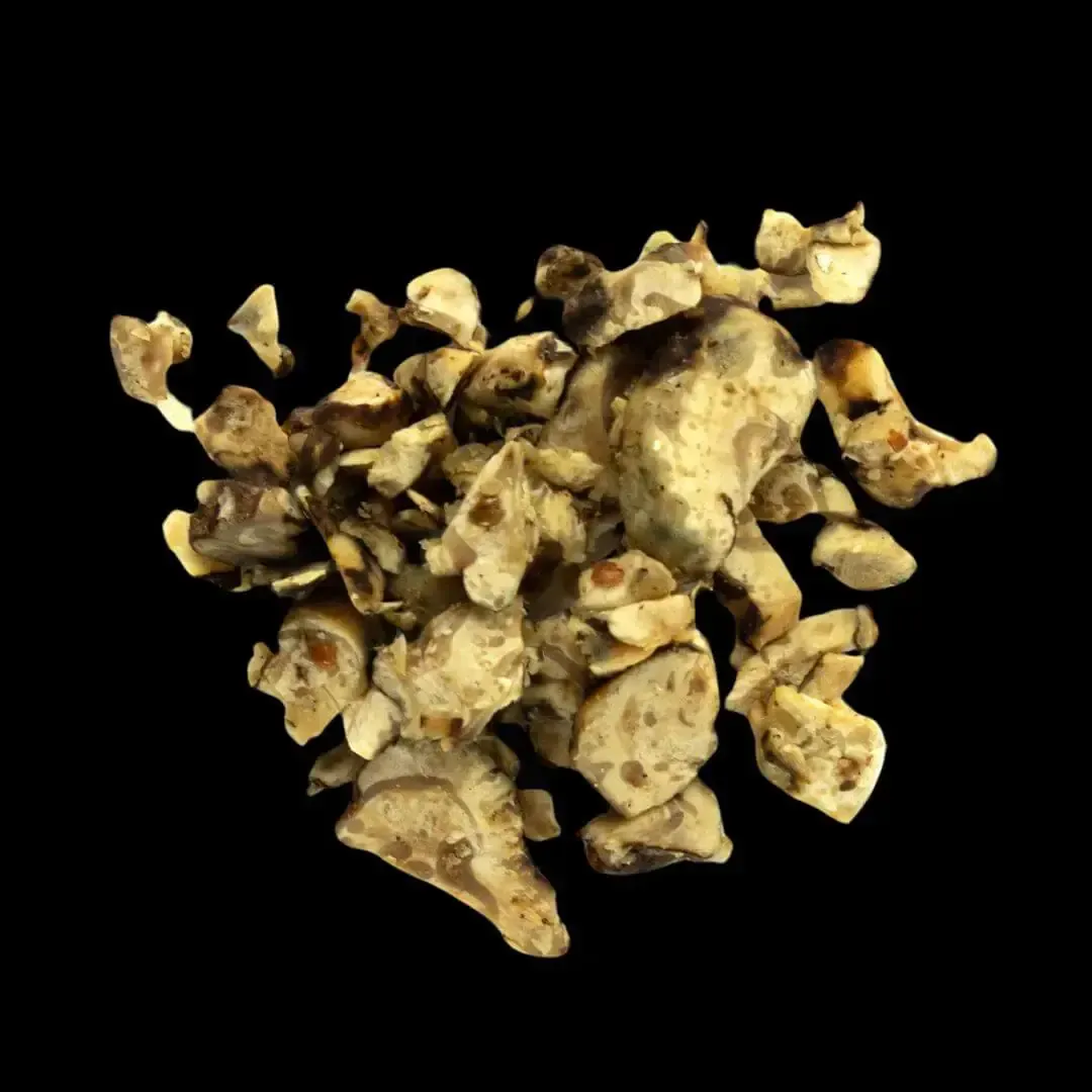 Pila de trozos de trufa de color beige y marrón sobre fondo negro.