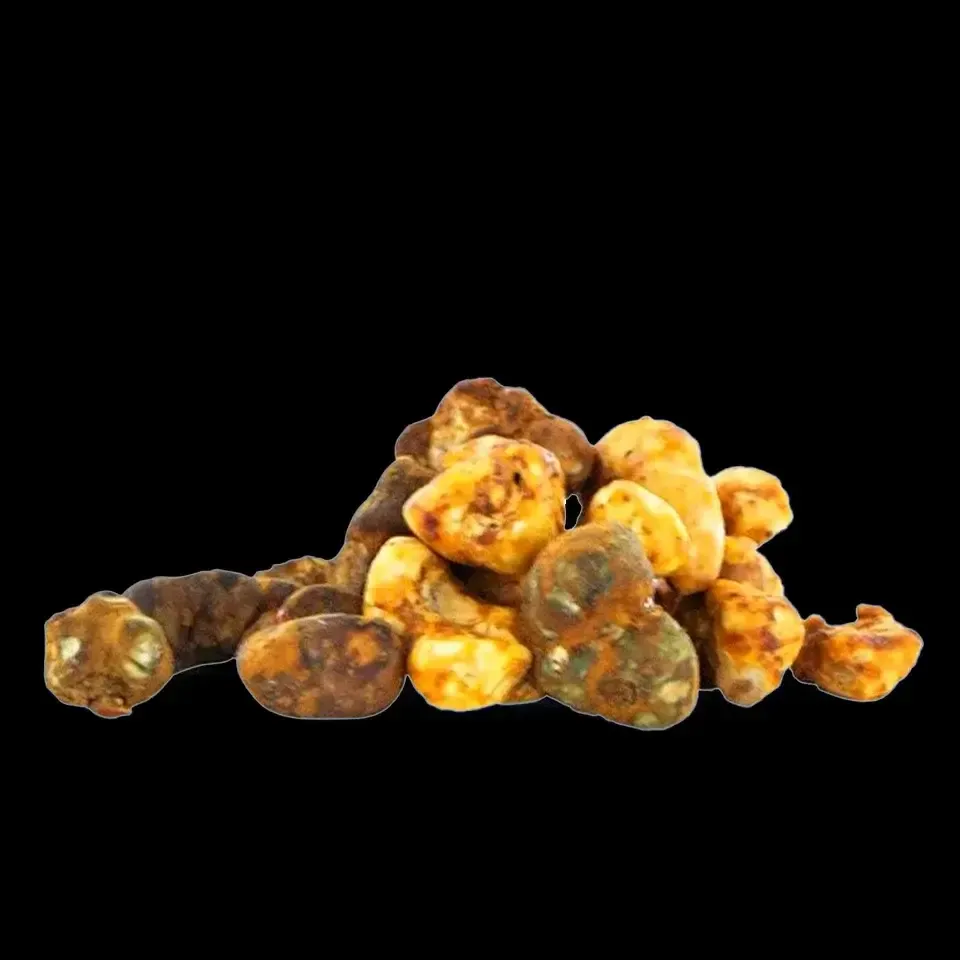 Montón de trufas de color claro y forma irregular, algunas con zonas marrones moteadas, sobre fondo negro.