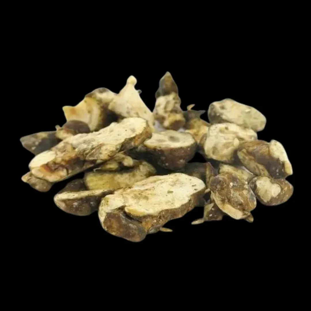 Montón de trozos de alcachofa de Jerusalén secos, de color marrón claro y tostado.