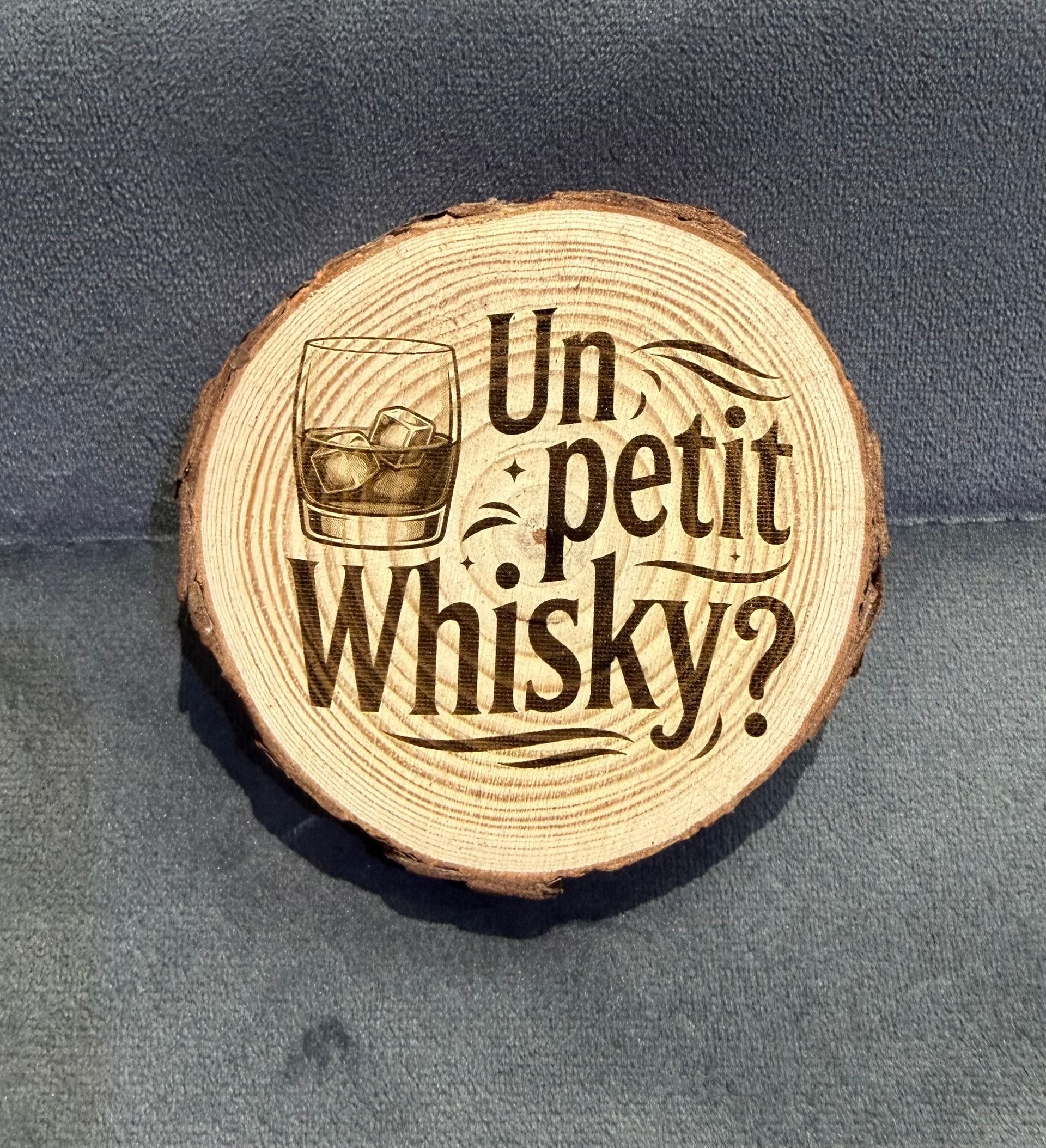 Rondin de bois ronde gravée de Un petit whisky ? sur un fond texturé sombre