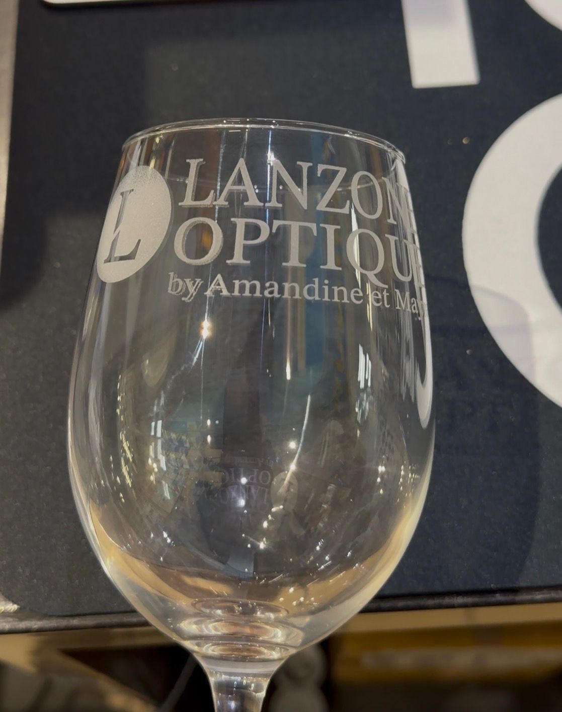 Verre à vin avec une gravure, posé sur une table sombre