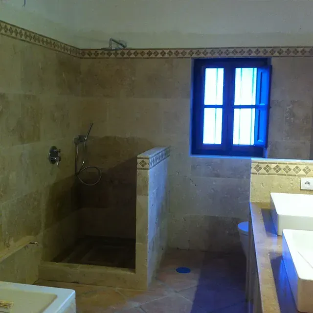 Un baño con ducha a ras de suelo y ventana.