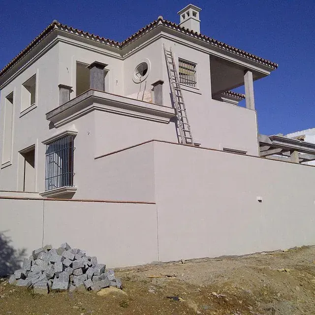 Una casa blanca con una escalera encima.