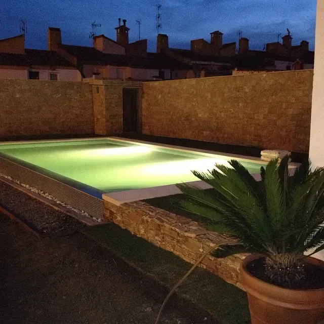 Una gran piscina está iluminada por la noche