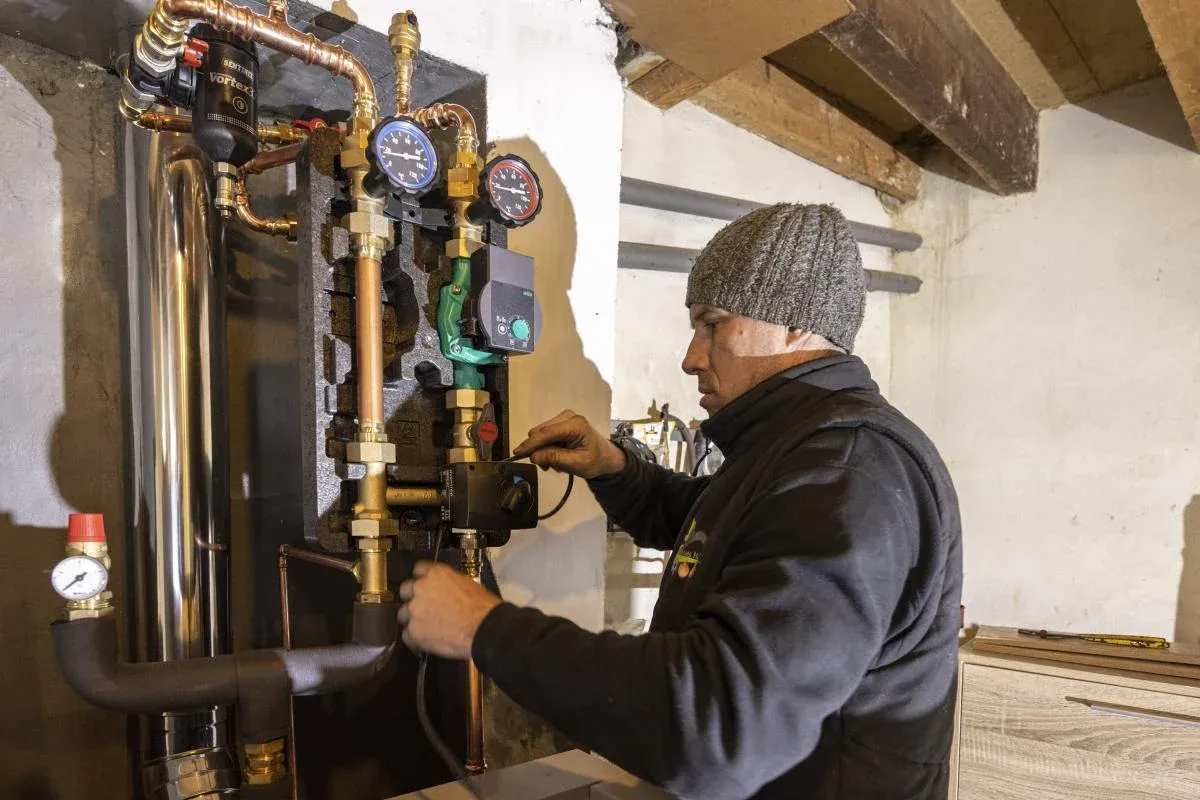 Pose d'une chaudière à granulés par un chauffagiste dans une maison