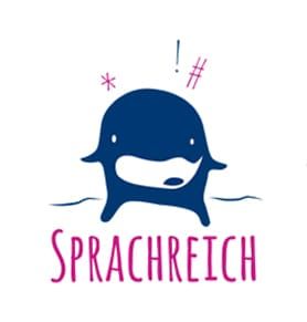 Blaues Sprachmaskottchen mit pinkfarbenem Schriftzug &bdquo;SPRACHREICH&ldquo; darunter und kleinen Glitzerpartikeln dar&uuml;ber.
