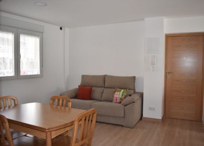 Una sala de estar con un sofá, una mesa y sillas.