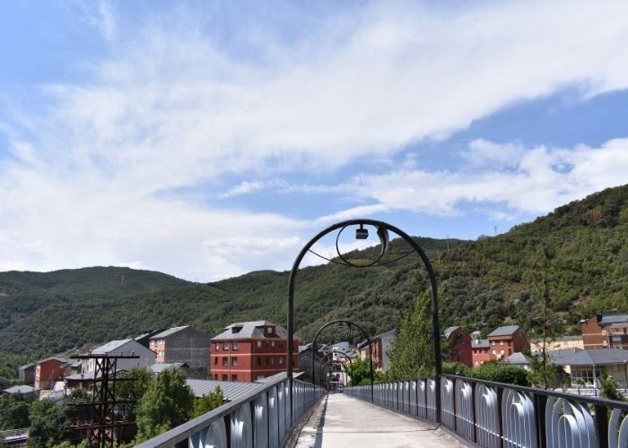 Un puente sobre un río con montañas al fondo