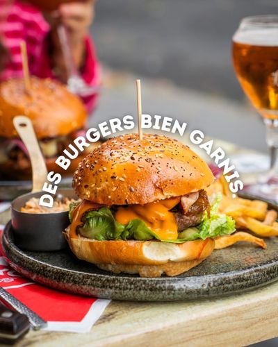 Burger accompagné de frites et d’une sauce à tremper dans une assiette