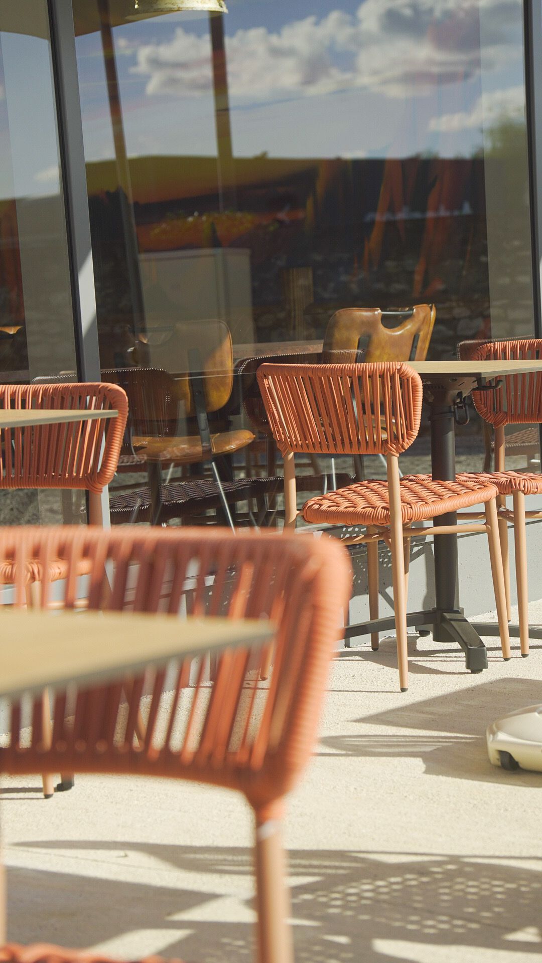Des mains tenant une tasse de café et un sac en papier kraft à emporter dans un café tamisé