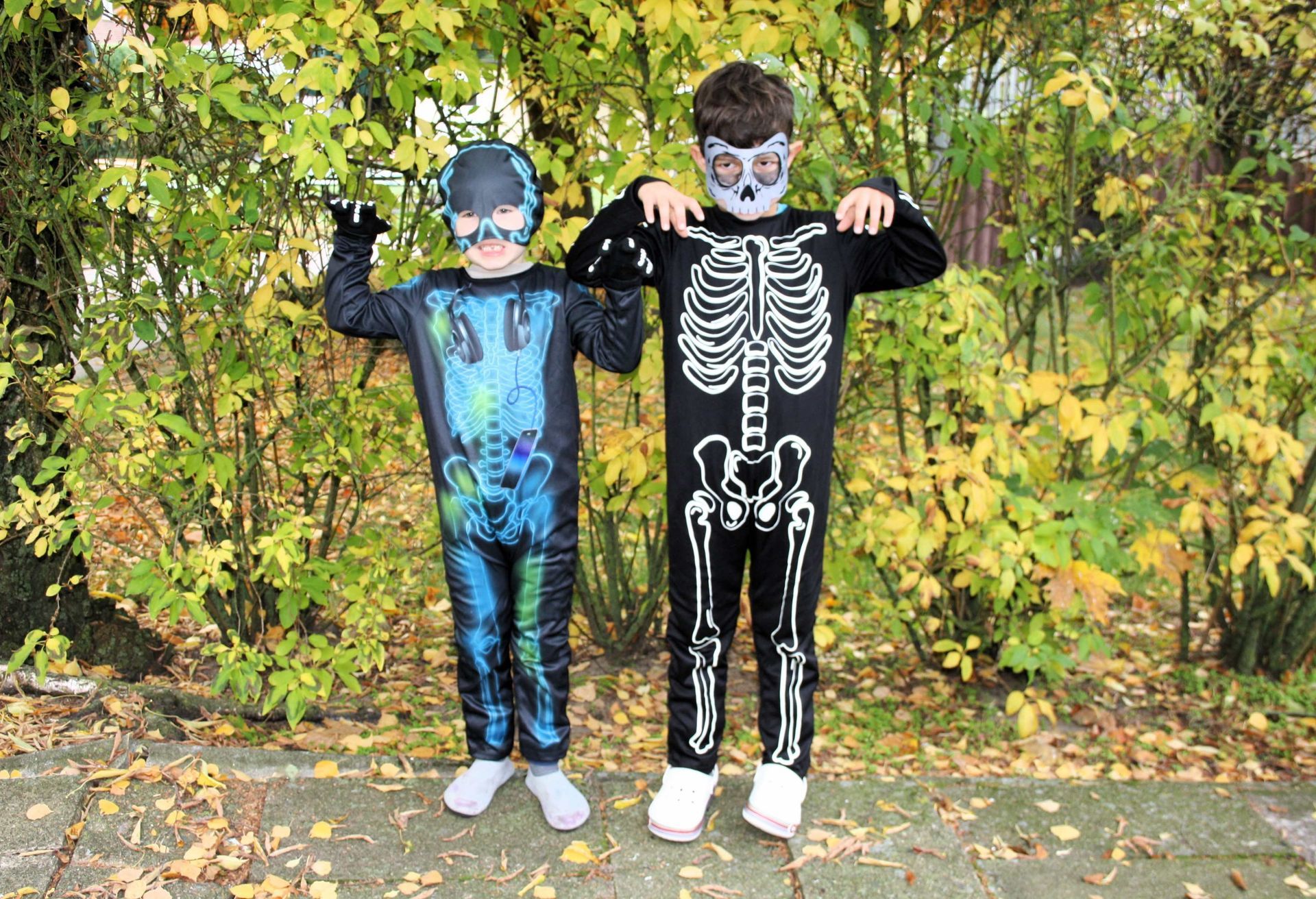 Two children in halloween costumes are standing next to each other.