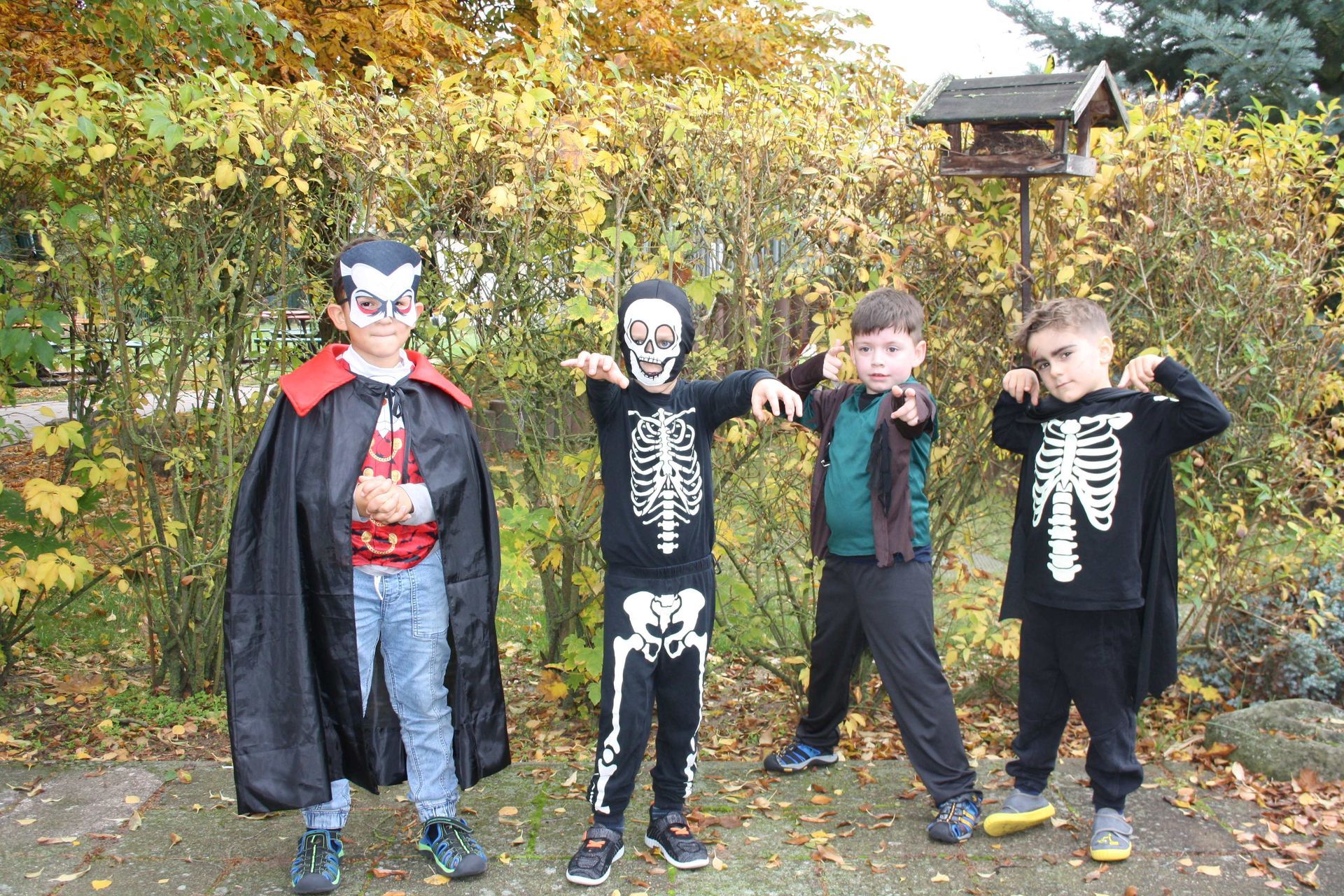A group of children dressed in halloween costumes are posing for a picture.