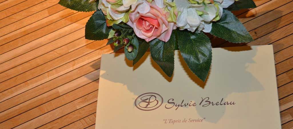 Bouquet de fleurs posé sur une invitation de mariage couleur crème, sur une table en bois