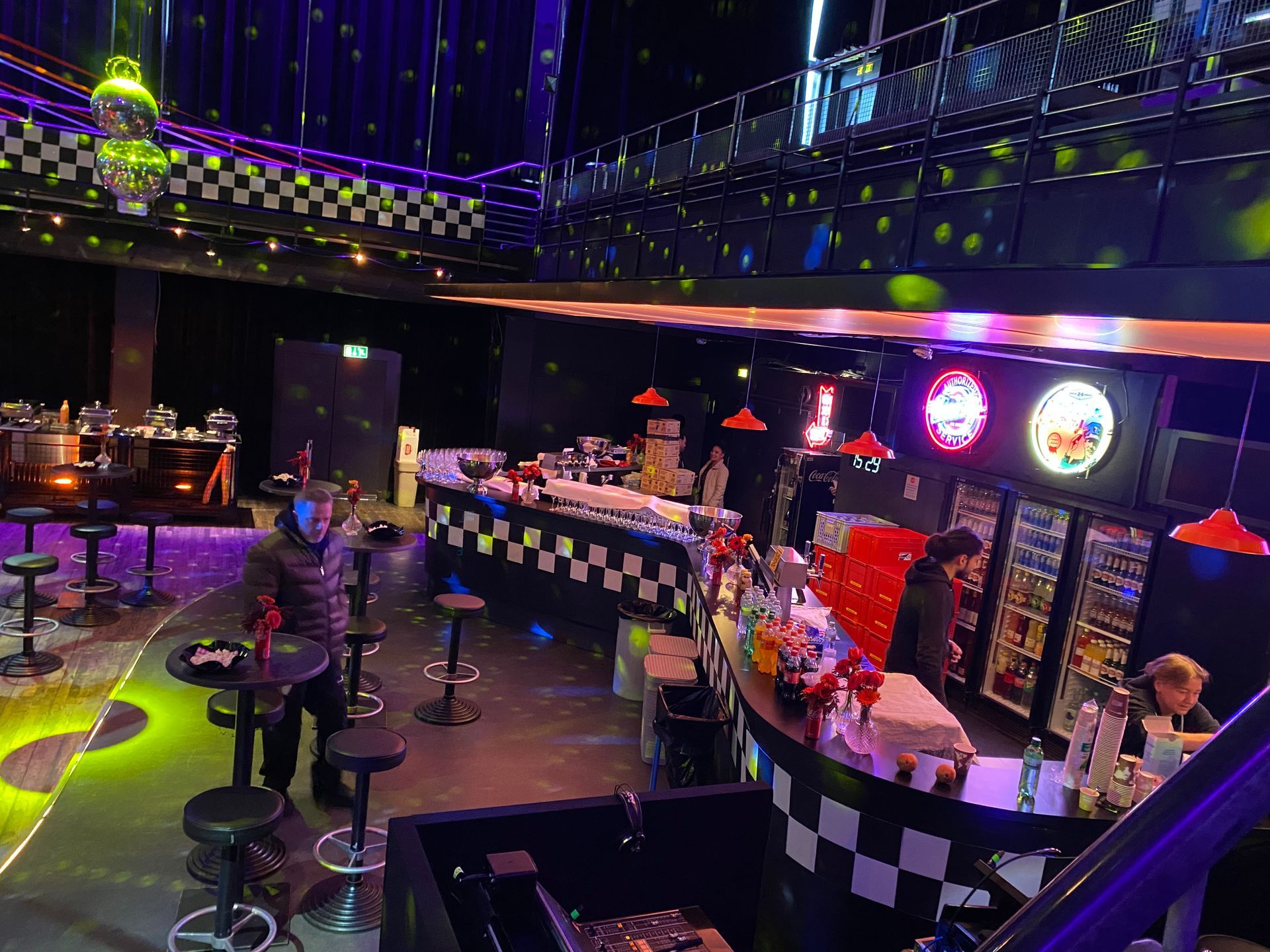 Bar décoré en damier noir et blanc, tables hautes et spots