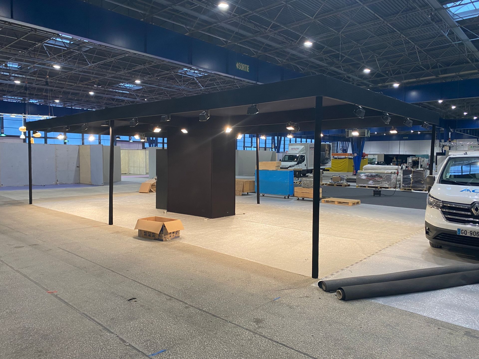Parc des expositions avec un stand noir en construction