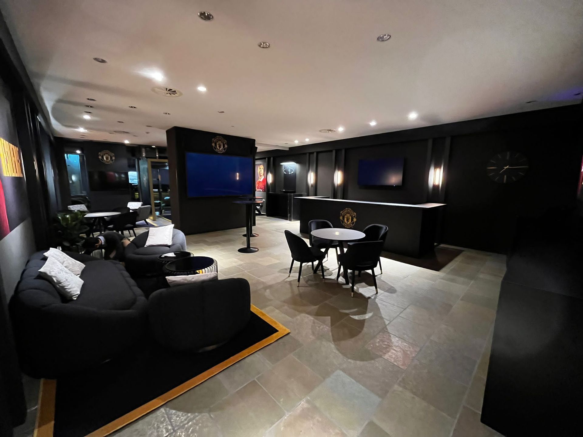 Intérieur d'un hôtel, avec un bar et des tables rondes, privatisé pour un évènement sportif