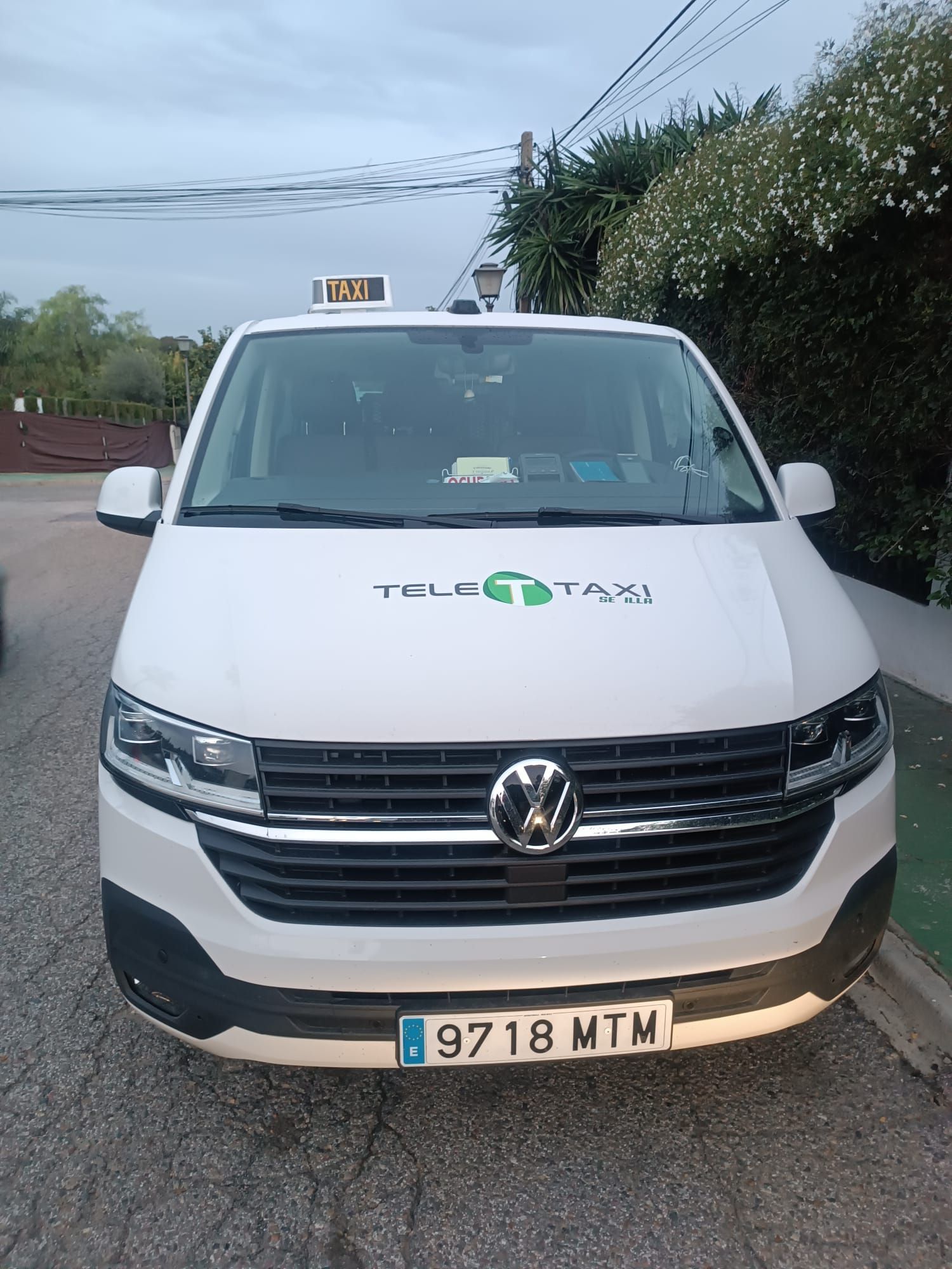 Una furgoneta Volkswagen blanca está estacionada al costado de la carretera.