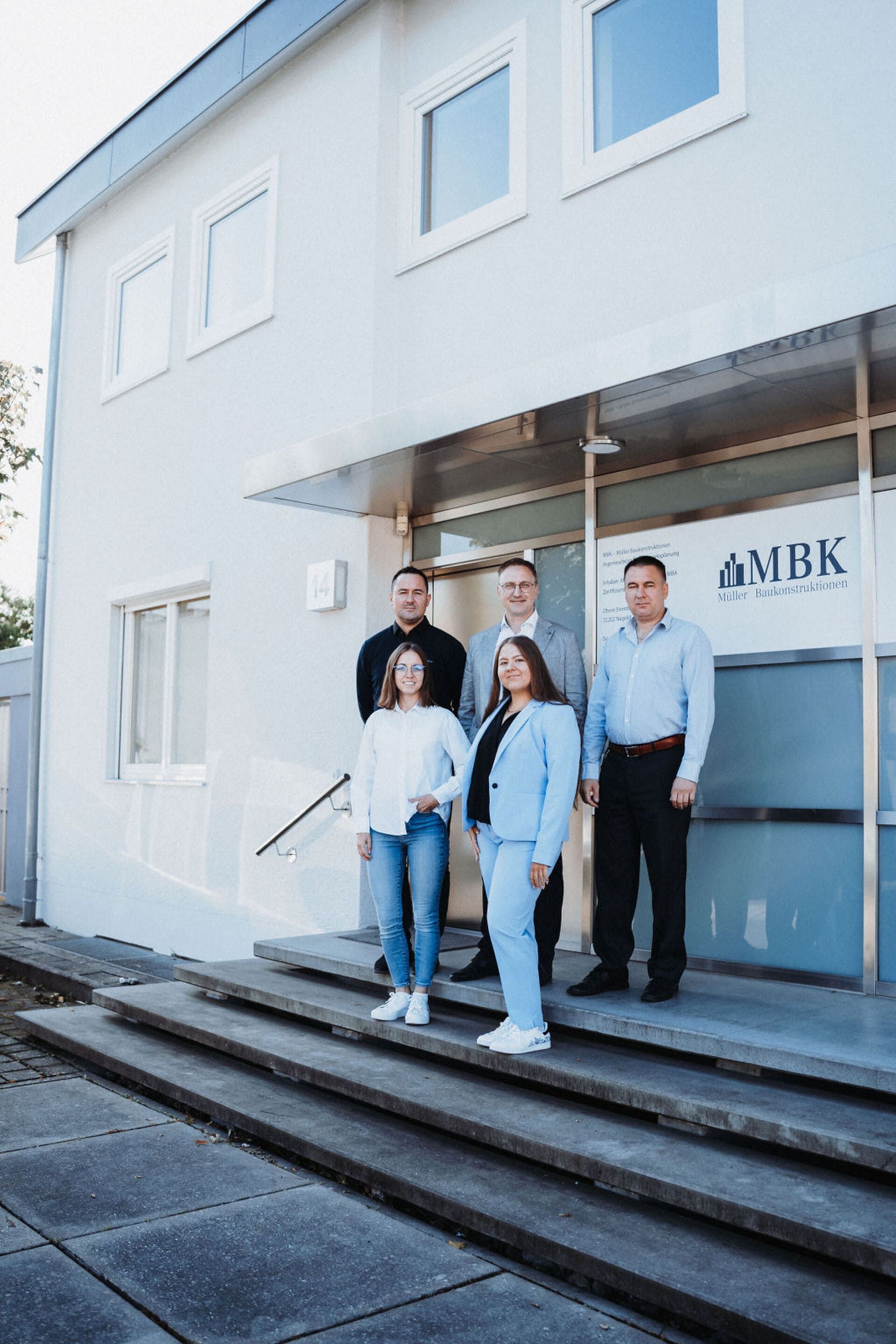 Eine Gruppe von Menschen steht auf den Stufen eines Gebäudes.