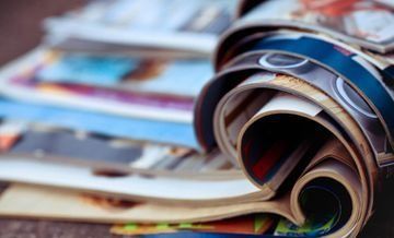 Un primer plano de una pila de revistas sobre una mesa.