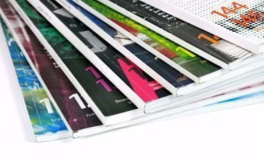 Un primer plano de una pila de revistas sobre un fondo blanco.