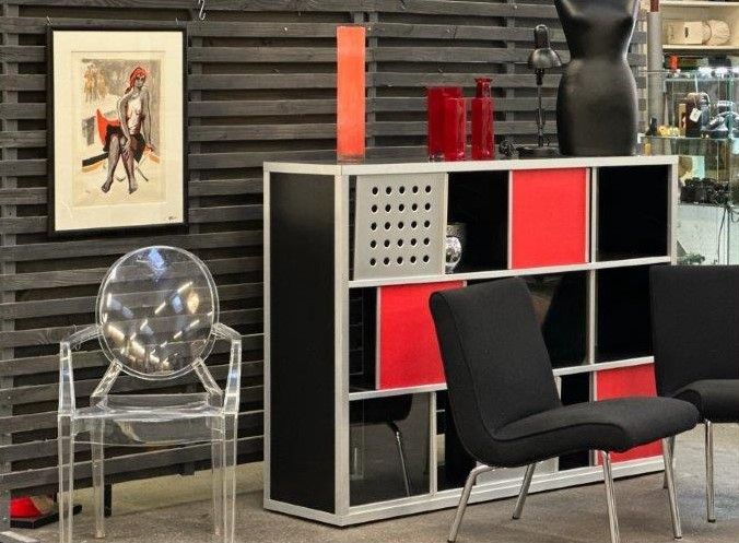 Ein Raum mit Stühlen, einem Regal und einem Bild an der Wand