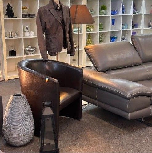 Ein Wohnzimmer mit einer Couch, einem Sessel und einer Lampe