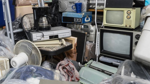 Encombrement de plusieurs objets du quotidien comme écran télévision, cafetière, lecteurs, des poches remlplie de linge etc.