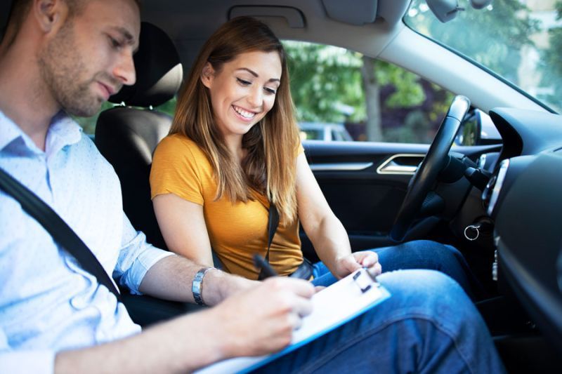 Fahrlehrer und Schülerin im Auto