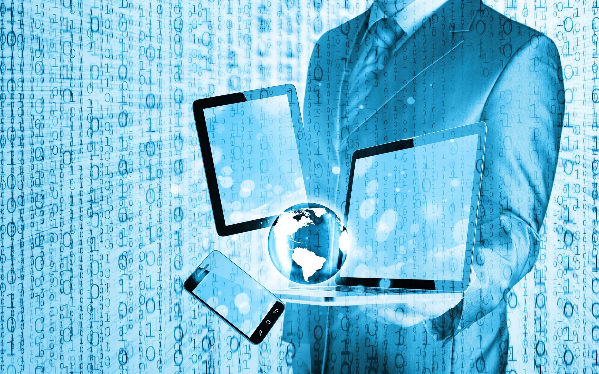 Un hombre con traje sostiene una computadora portátil y una tableta.