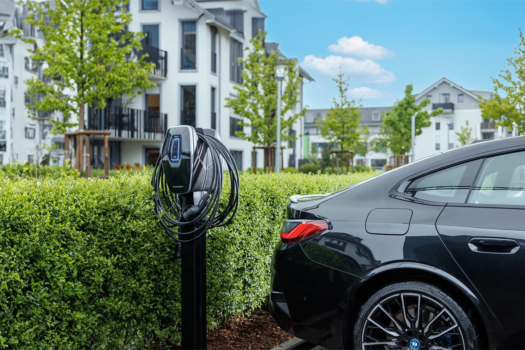An einer Parkhauswand sind Ladestationen für Elektrofahrzeuge mit nummerierten Stellplätzen angebracht.