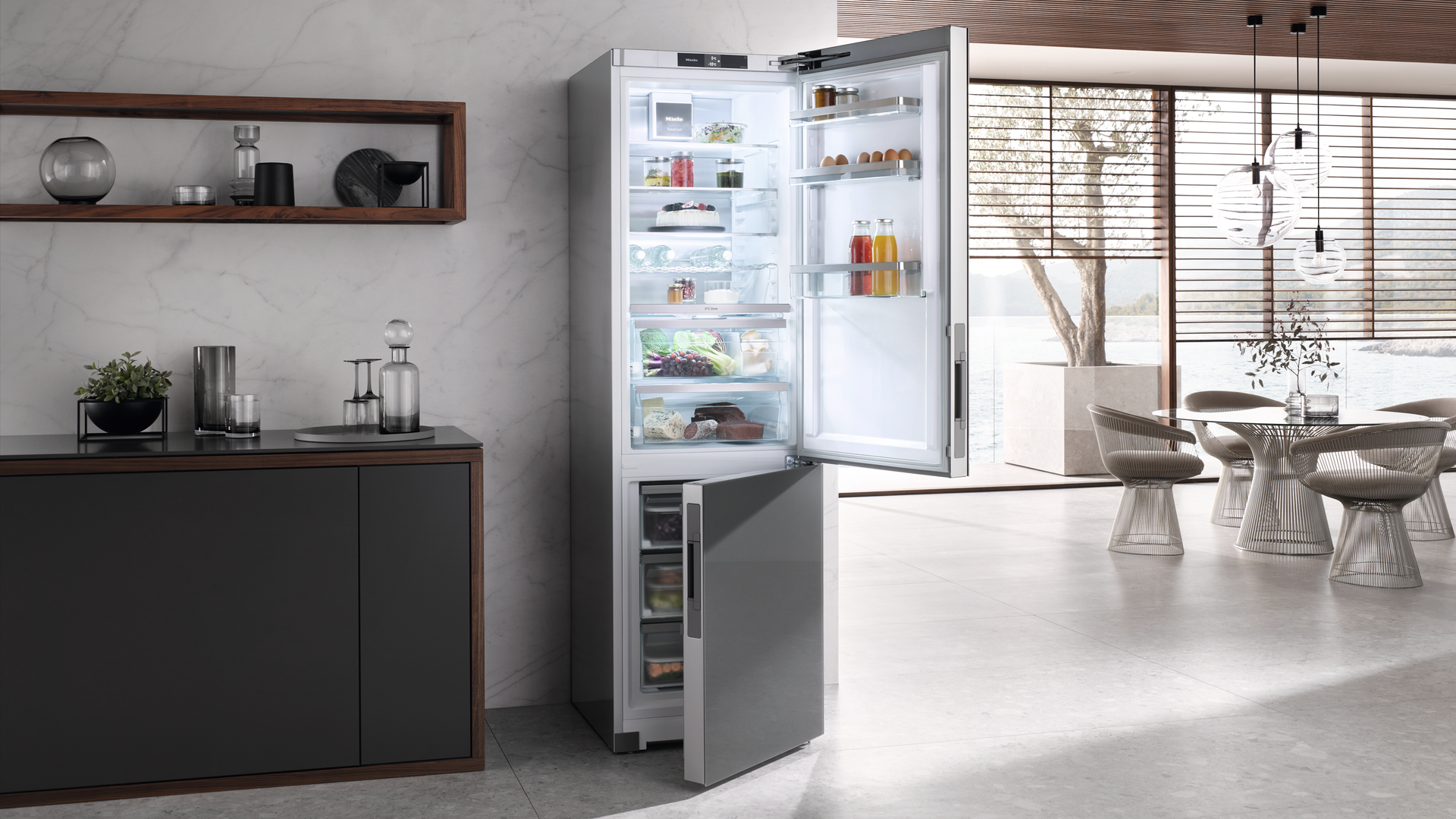 Ein hoher Kühlschrank aus Edelstahl mit beiden geöffneten Türen steht in einer modernen Küche mit einem Essbereich im Hintergrund.