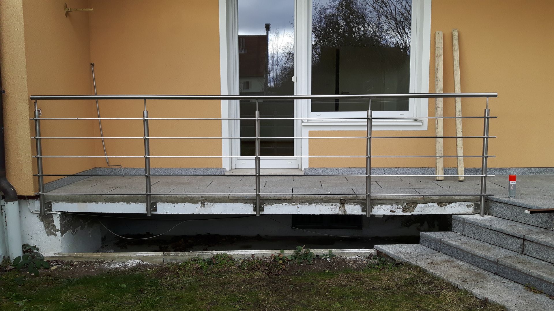 Ein Edelstahl-Geländer an einem kurzen Treppenaufgang