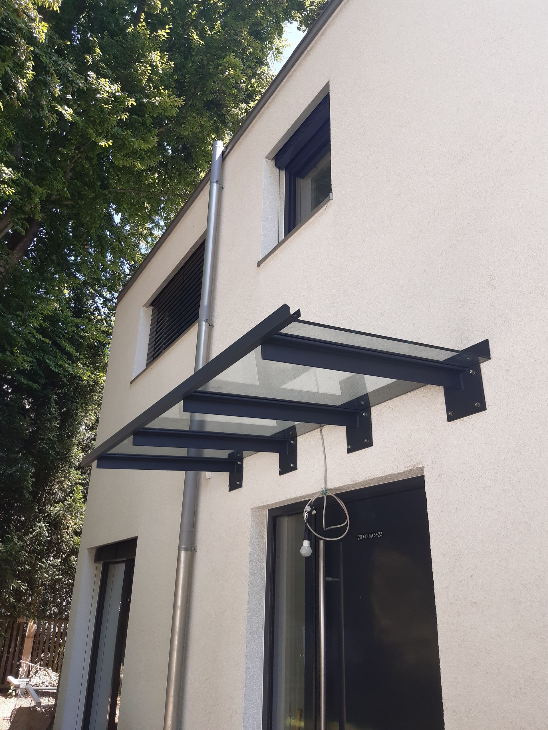 Ein Metallvordach an einer hellen Außenwand