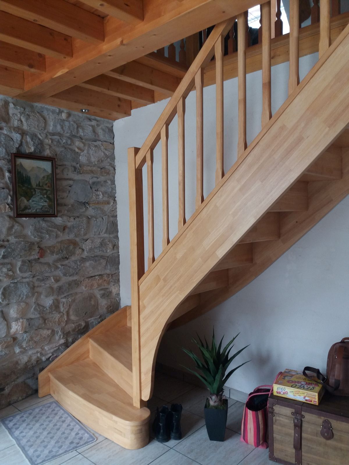 Escalier en bois avec garde-corps en métal, dans un intérieur lumineux.