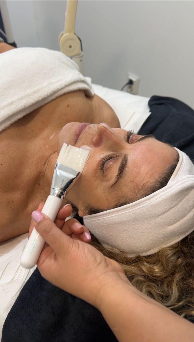 Pessoa recebendo massagem com pedras quentes nas costas, com as mãos aplicando as pedras.