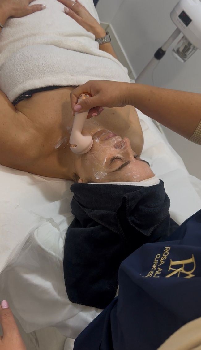 Pessoa recebendo massagem com pedras quentes nas costas, com as mãos aplicando as pedras.